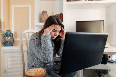 Young woman using mobile phone at home