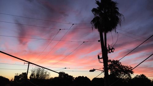 Low angle view of silhouette trees against dramatic sky