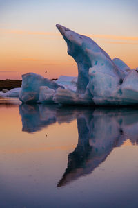 Scenic view of frozen lake against sky during sunset