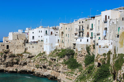 Buildings in city against clear blue sky