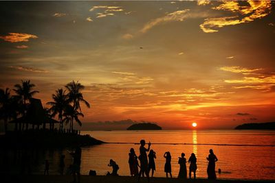 Silhouette of people in sea at sunset