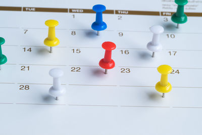 High angle view of thumbtack on calendar