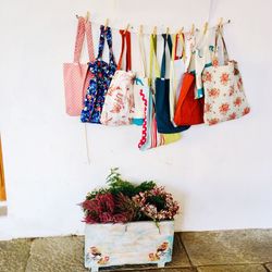 Bags hanging over potted plant against wall
