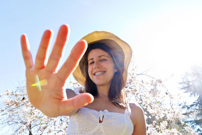 Low angle view of young woman against sky