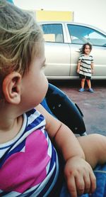 Portrait of cute girl sitting on wall