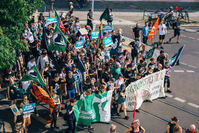 High angle view of people protesting on street in city