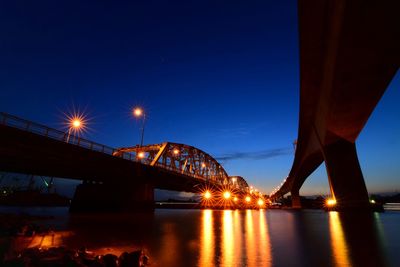 Illuminated bridges over river at night