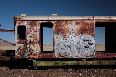 Graffiti on abandoned train against sky