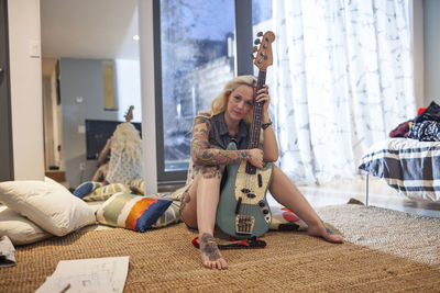 Beautiful young woman playing an electric guitar