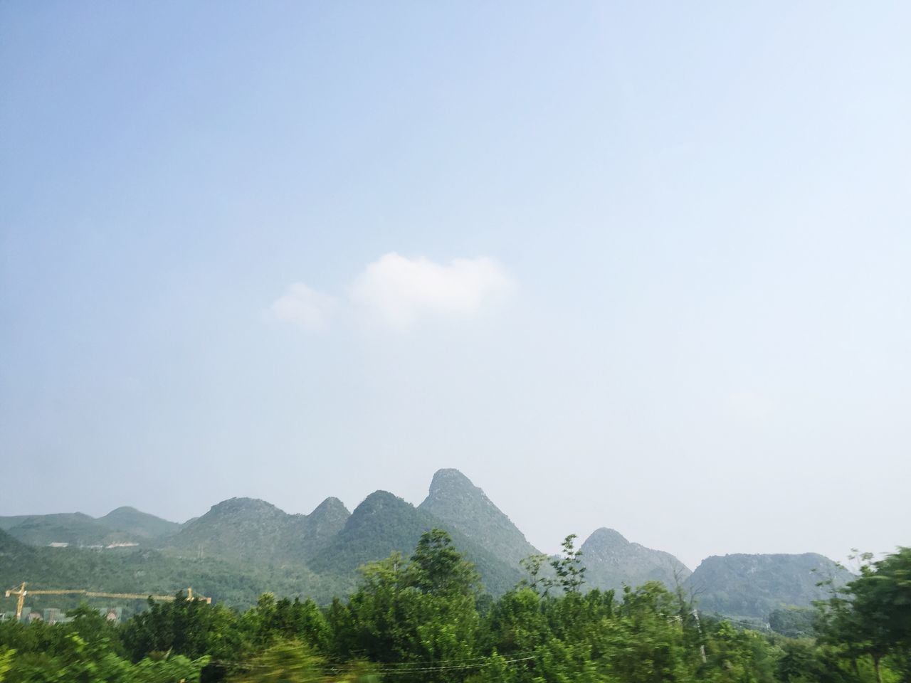 mountain, tranquility, tranquil scene, tree, scenics, copy space, mountain range, beauty in nature, clear sky, nature, landscape, sky, blue, non-urban scene, day, idyllic, hill, remote, outdoors, low angle view