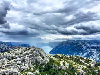 Scenic view of mountains and river against cloudy sky