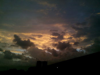 Silhouette of building against dramatic sky