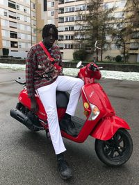 Man riding motor scooter on city street