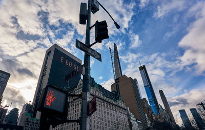 Low angle view of buildings against sky with street signs