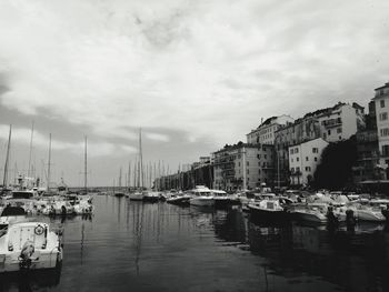 Boats moored in harbor against buildings in city