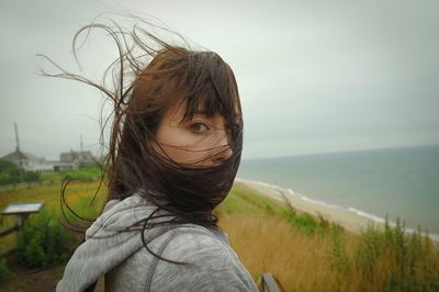 Portrait of woman on beach against sky