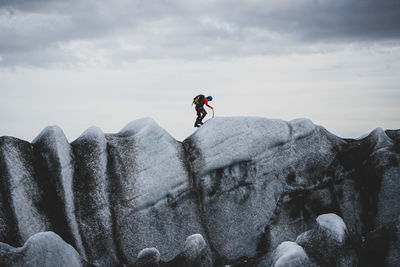 Man on rock against sky