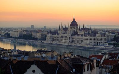 High angle view of hungarian parliament building by river in sky during sunrise