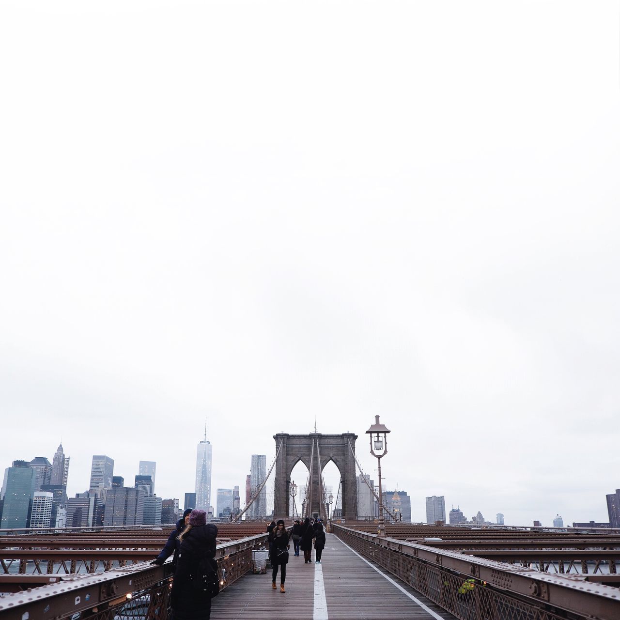 architecture, built structure, city, men, walking, building exterior, person, clear sky, copy space, lifestyles, transportation, city life, the way forward, bridge - man made structure, connection, railing, road, sky, large group of people