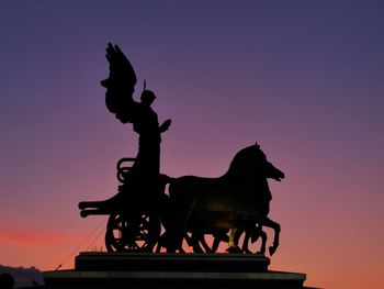 Chariot statue silhouette with sunset in background