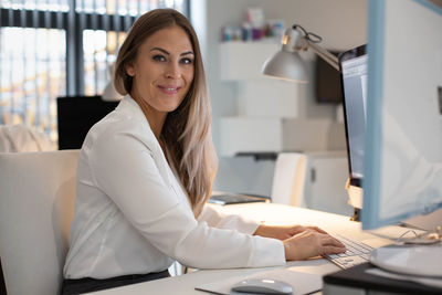 Portrait of smiling woman sitting at table