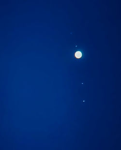 Low angle view of moon against blue sky at night
