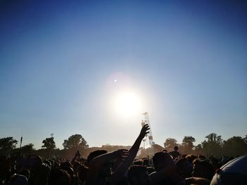 Crowd at music concert against sky
