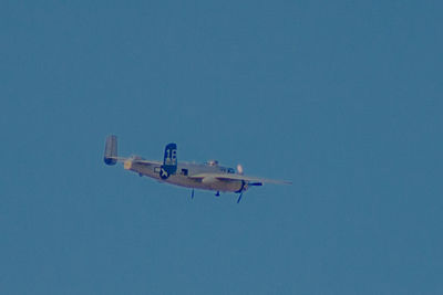 Low angle view of airplane flying against clear blue sky