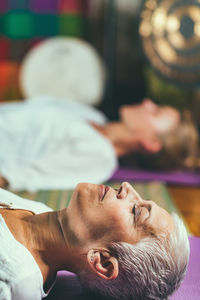 Close-up of mature woman lying with daughter at spa