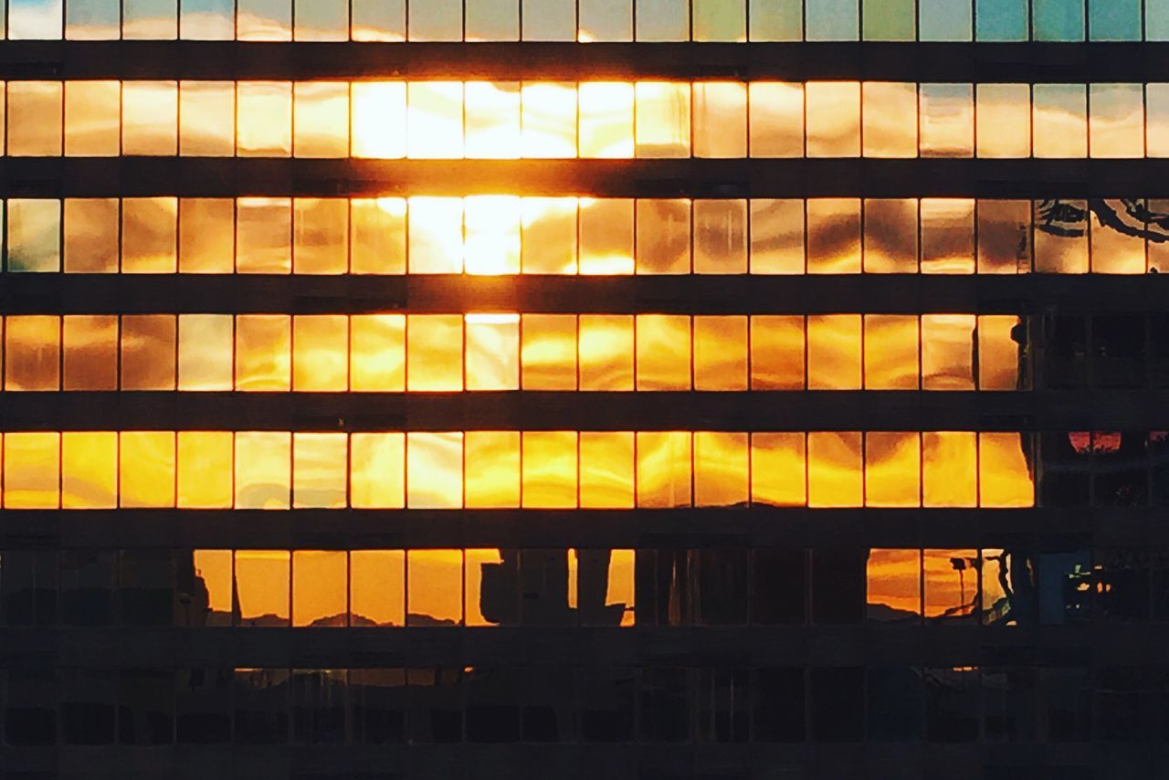 architecture, built structure, yellow, building exterior, illuminated, orange color, sunset, city, modern, building, low angle view, glass - material, reflection, window, night, no people, pattern, outdoors, office building, full frame