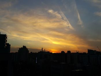 Silhouette cityscape against sky during sunset