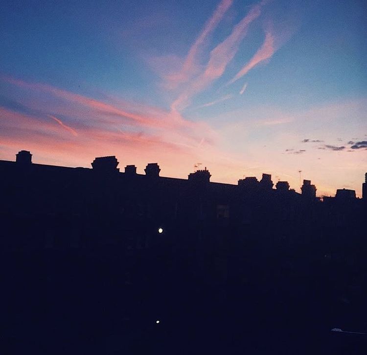 SILHOUETTE BUILDINGS AGAINST ORANGE SKY