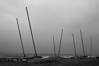 Sailboats moored on sea against sky