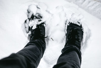 Low section of man standing on snow