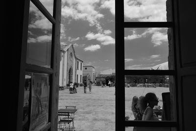 People in front of buildings against sky