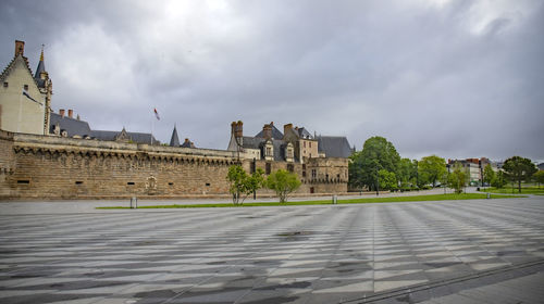 Buildings in city against cloudy sky