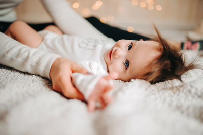 Portrait of cute baby lying on bed at home