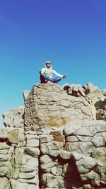 Low angle view of man standing against clear blue sky