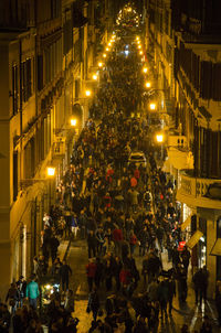 High angle view of people on illuminated street at night