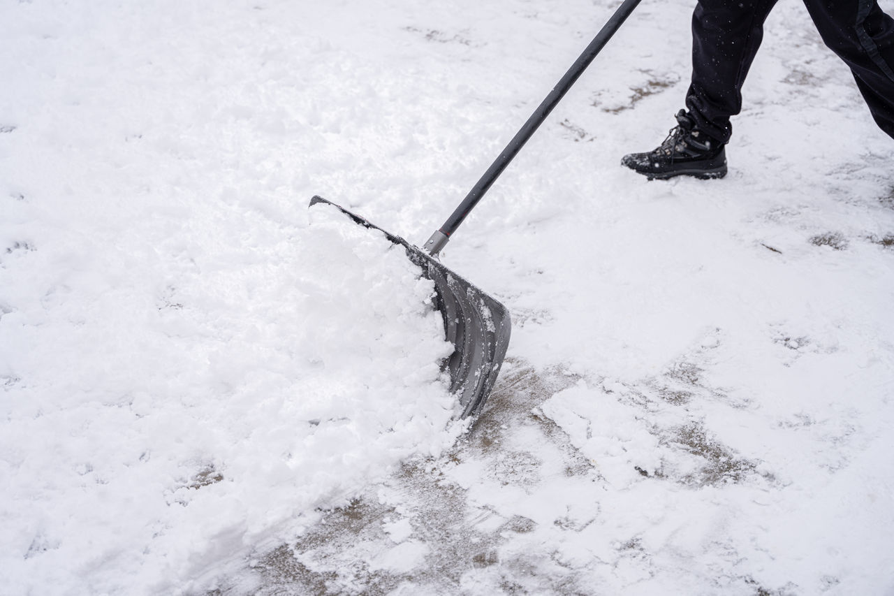 LOW SECTION OF PERSON ON SNOW COVERED LAND