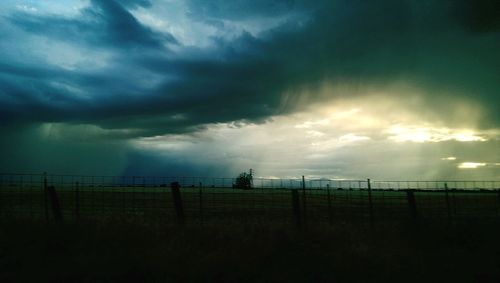 Scenic view of field against cloudy sky