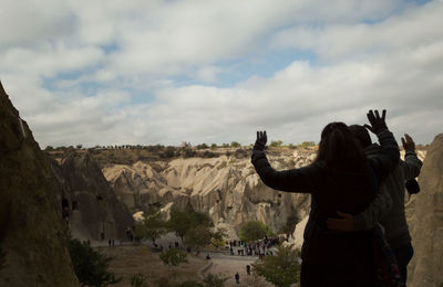 Rear view of woman photographing on rock