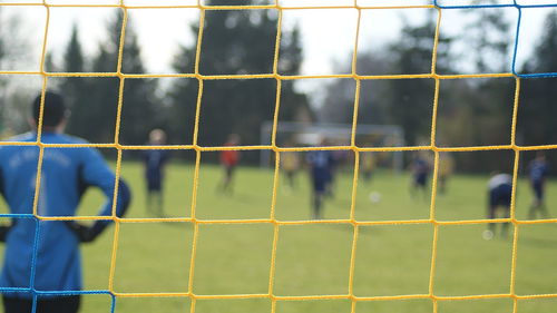 Players on soccer field seen through net