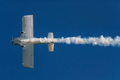 Low angle view of airplane against clear blue sky