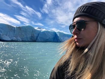 Close-up of young woman wearing sunglasses against sea and sky