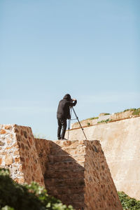 Rear view of man standing against wall