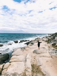 Man standing on beach against sky