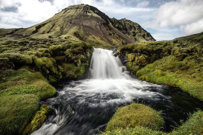 Scenic view of waterfall against sky