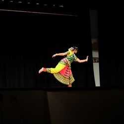 Young woman jumping on stage