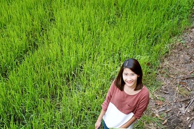 High angle portrait of young woman standing on field